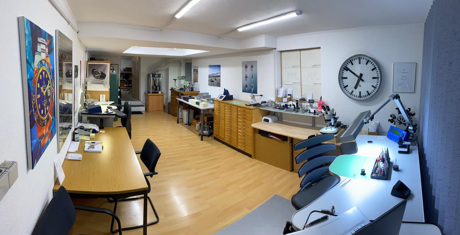 Werkstatt von Uhrenservice Franz mit Werktischen, Maschinenpark, Bahnhofsuhr und Rolex-Kunstbild